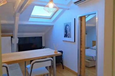 a dining room with a table and a skylight at Isabelli Appartement plein centre avec place de parking in Aix-en-Provence