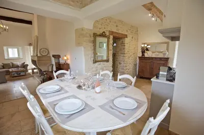 a dining room with a white table and white chairs at Authentique propriété in Bonnieux