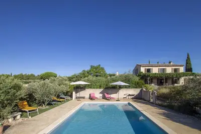 a pool with chairs and umbrellas and a house at Mas de Lavande in Saint-Rémy-de-Provence