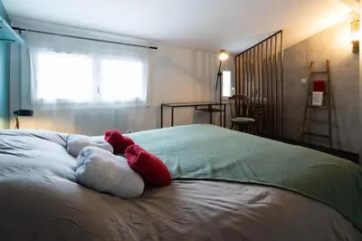 a red and white stuffed animal laying on a bed at Alma Viva - Piscine Privée - Climatisée - Parking in Velaux
