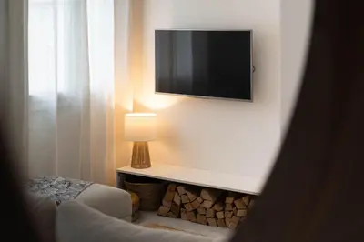 a living room with a television on a wall at Alma Viva - Piscine Privée - Climatisée - Parking in Velaux