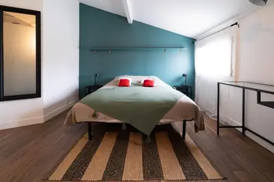 a bedroom with a bed with a blue wall at Alma Viva - Piscine Privée - Climatisée - Parking in Velaux
