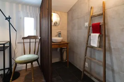a bathroom with a sink and a mirror and a chair at Alma Viva - Piscine Privée - Climatisée - Parking in Velaux