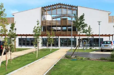 a large white building with a playground in front of it at 104 Douce Provence au calme face à la piscine in Éguilles