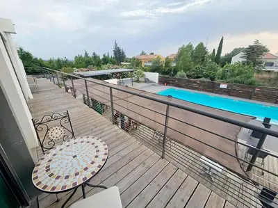 a balcony with a table and chairs and a pool at 104 Douce Provence au calme face à la piscine in Éguilles