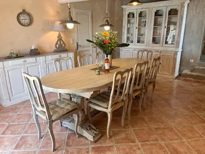 a dining room table with chairs and a vase of flowers at La Paradisse – exceptional Provençal farmhouse (18th century) in Blauvac