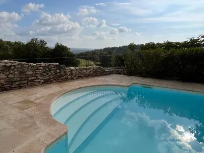 a swimming pool in a yard with a stone wall at La Paradisse – exceptional Provençal farmhouse (18th century) in Blauvac