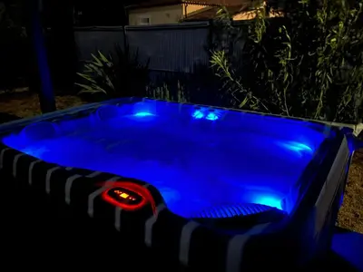 a pool with blue lights in a backyard at night at Pause spa sur la route du Ventoux adults only in Carpentras