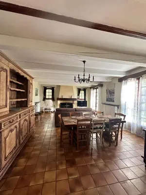 a kitchen with white cabinets and a table and chairs at VILLA DE LA ROQUE in Eygalières
