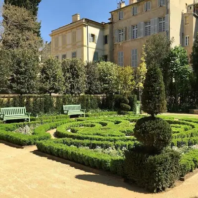 a garden with two benches and a hedge at Sublime Appartement 6 couchages avec Parking (Aix-en-Provence) in Aix-en-Provence