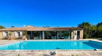 a large swimming pool in front of a house at LUBERON SOLEIL ET OLIVIERS in Les Taillades