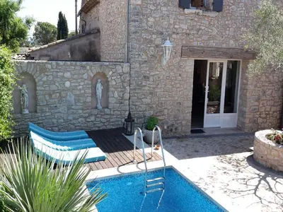 a swimming pool in front of a stone house at Bliss Near Aix-en-Provence in Venelles