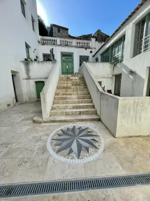 a set of stairs leading to a building with a green door at Jacuzzi & Terrasse en bord de rivière in Fontaine-de-Vaucluse