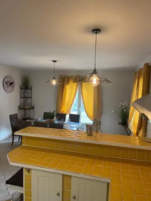 a kitchen with yellow curtains and a counter top at Villa provençale 8 personnes in Ventabren