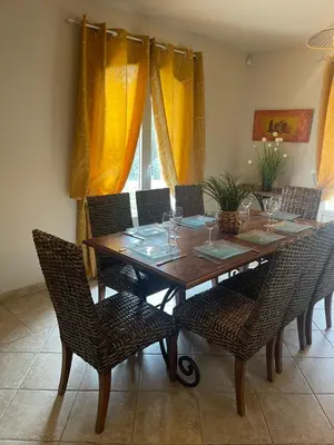 a dining room table with chairs and a table with wine glasses at Villa provençale 8 personnes in Ventabren
