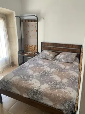 a bedroom with a bed with a comforter on it at La studette provençale in Jouques