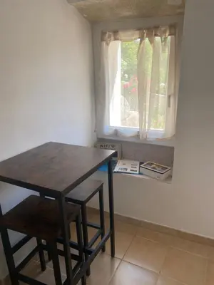 a table and a chair in a room with a window at La studette provençale in Jouques