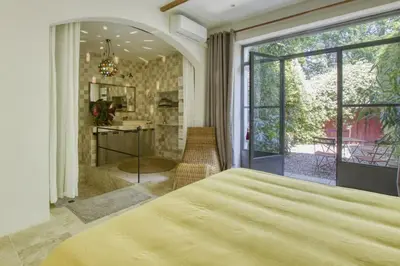 a bedroom with a large bed and a large window at Le Mas des Anges in Cabannes