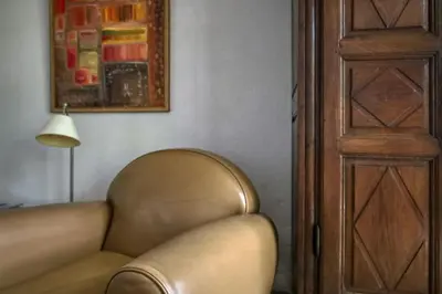 a brown leather couch in a room with a lamp at Le Mas des Anges in Cabannes