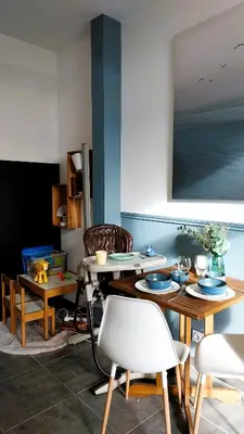 a living room with tables and chairs and a painting at L'appartement de l'Arche in Châteauneuf-de-Gadagne
