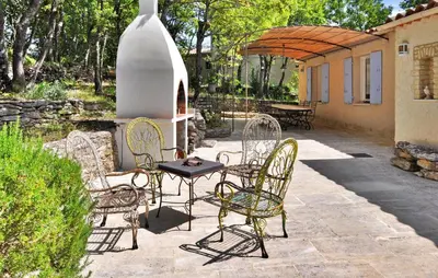 a group of chairs and a table on a patio at La Villa Du Soleil in Lacoste