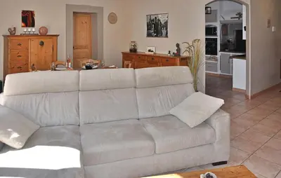 a living room with a white couch and a kitchen at La Villa De Sacha in Vedène
