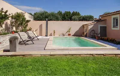a swimming pool in a yard with chairs and a house at La Villa De Sacha in Vedène