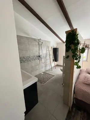 a bathroom with a shower and a sink and a tub at 84A - 