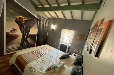 a bedroom with an elephant painting on the wall at 84A - 
