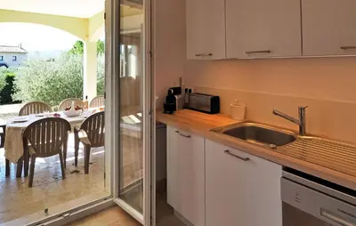 a kitchen with a sink and a table with chairs at Li Vue Vent in Saint-Rémy-de-Provence