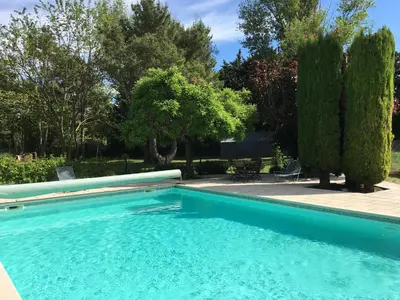 a swimming pool in a yard with trees at The Garden View in Le Thor