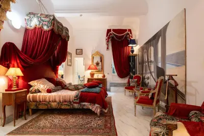 a bedroom with a bed with red drapes at Appartement de luxe : Le Petit Trianon au coeur d'Aix-en-Provence in Aix-en-Provence