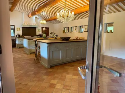 a large kitchen with a large island in the middle at Domaine de Valloncourt in Cheval-Blanc