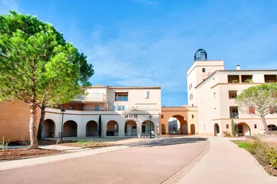 a building with a clock tower on top of it at Village Pont Royal en Provence - maeva Home - Appartement climatisé 4 pièces 6 personnes - Prestige MAE-3234 in Mallemort