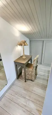 a table with a lamp and a chair in a room at Lou Mas dou Souleou & Spa in Cheval-Blanc