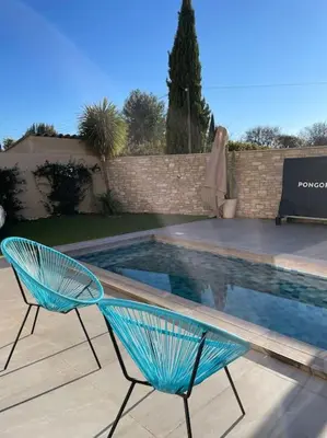 a blue chair sitting next to a swimming pool at L'Artiste - Villa 5 min du centre historique d'Aix in Aix-en-Provence