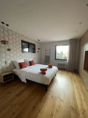 a bedroom with a large white bed with red pillows at L'Artiste - Villa 5 min du centre historique d'Aix in Aix-en-Provence