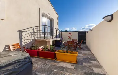 a balcony with a table and chairs on a building at Beautiful Apartment In Eyragues in Eyragues