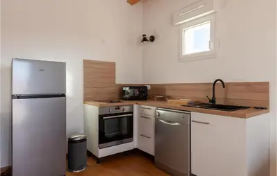 a kitchen with a white refrigerator and a sink at Beautiful Apartment In Eyragues in Eyragues