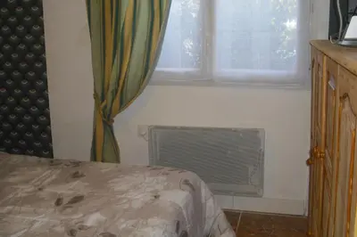 a bedroom with a bed and a window and a radiator at Lou mas li Pitchoun 