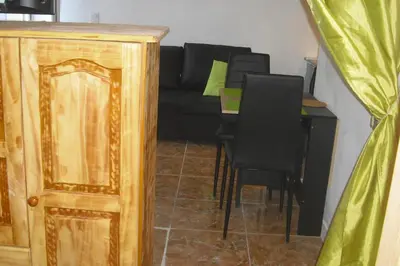 a living room with a black couch and a table at Lou mas li Pitchoun 