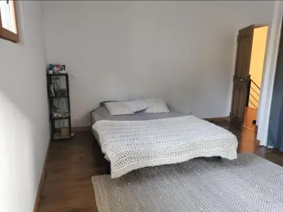 two beds in a room with white walls and wooden floors at Maison de la bonne fontaine. in Lauris