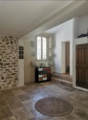 a large room with a stone wall and a window at Maison de la bonne fontaine. in Lauris