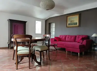 a living room with a red couch and a table at Superbe T3 avec terrasse en plein cœur du centre historique in Aix-en-Provence