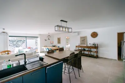 a kitchen and living room with a table and chairs at La Dolce Vita Provençale Charming House with its Private Swimming Pool in LʼIsle-sur-la-Sorgue