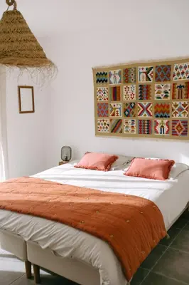 a bedroom with a large bed with two pink pillows at La Dolce Vita Provençale Charming House with its Private Swimming Pool in LʼIsle-sur-la-Sorgue