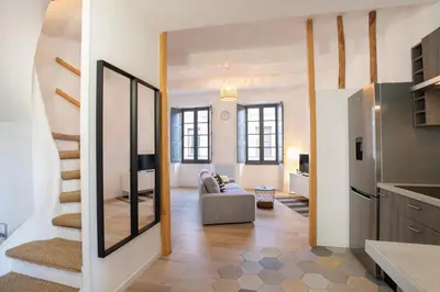 a living room with a couch and a mirror at Le Duplex - Hypercentre - Wifi in Carpentras
