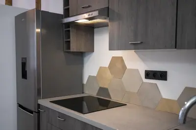 a kitchen with wooden cabinets and a counter top at Le Duplex - Hypercentre - Wifi in Carpentras