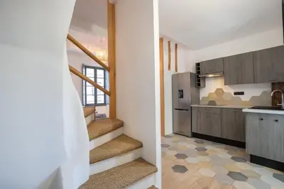 a kitchen with stairs and a kitchen with a refrigerator at Le Duplex - Hypercentre - Wifi in Carpentras