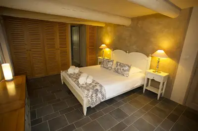a bedroom with a white bed with two lamps on it at La Petite Paradisse – mas provençal exceptionnel in Blauvac